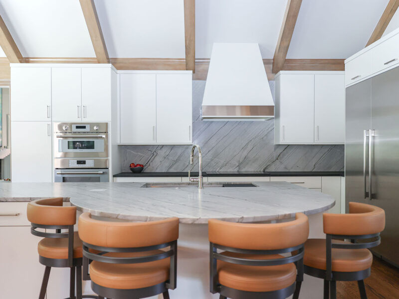 Tulsa kitchen design and remodel featuring a round island with seating, stainless steel appliances, and a counter-to-ceiling backsplash.