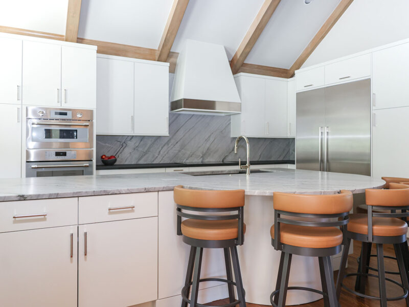 Vaulted ceiling Tulsa kitchen remodel featuring a large island with seating, maple cabinets, and a custom vent hood.